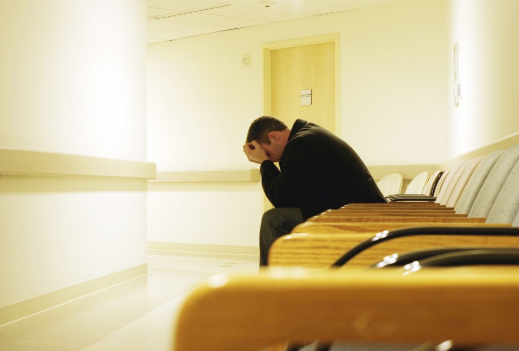 Man holding head in hands in VA hospital