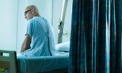 Veteran in Glasses Waiting on VA Bed
