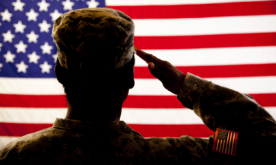 Silhouetted Soldier Saluting American Flag