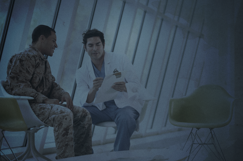 VA Doctor talking to Veteran in Camo in Waiting Room