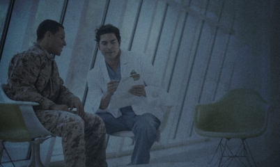 VA Doctor talking to Veteran in Camo in Waiting Room