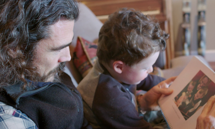 Veteran Showing Son Photo of their deployment