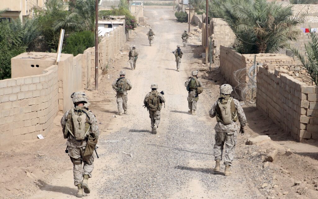 American Soldiers on Patrol down dusty road