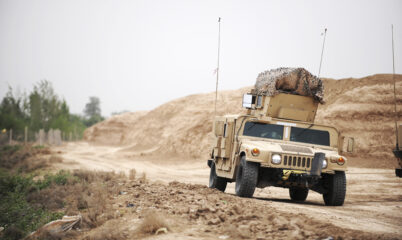 American Military Humvee Driving Down Desert Road