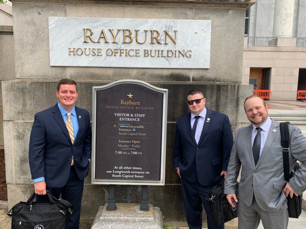 Three Ohio veterans pose in front of Rayburn office building before meetings with representatives to discuss veterans issues.